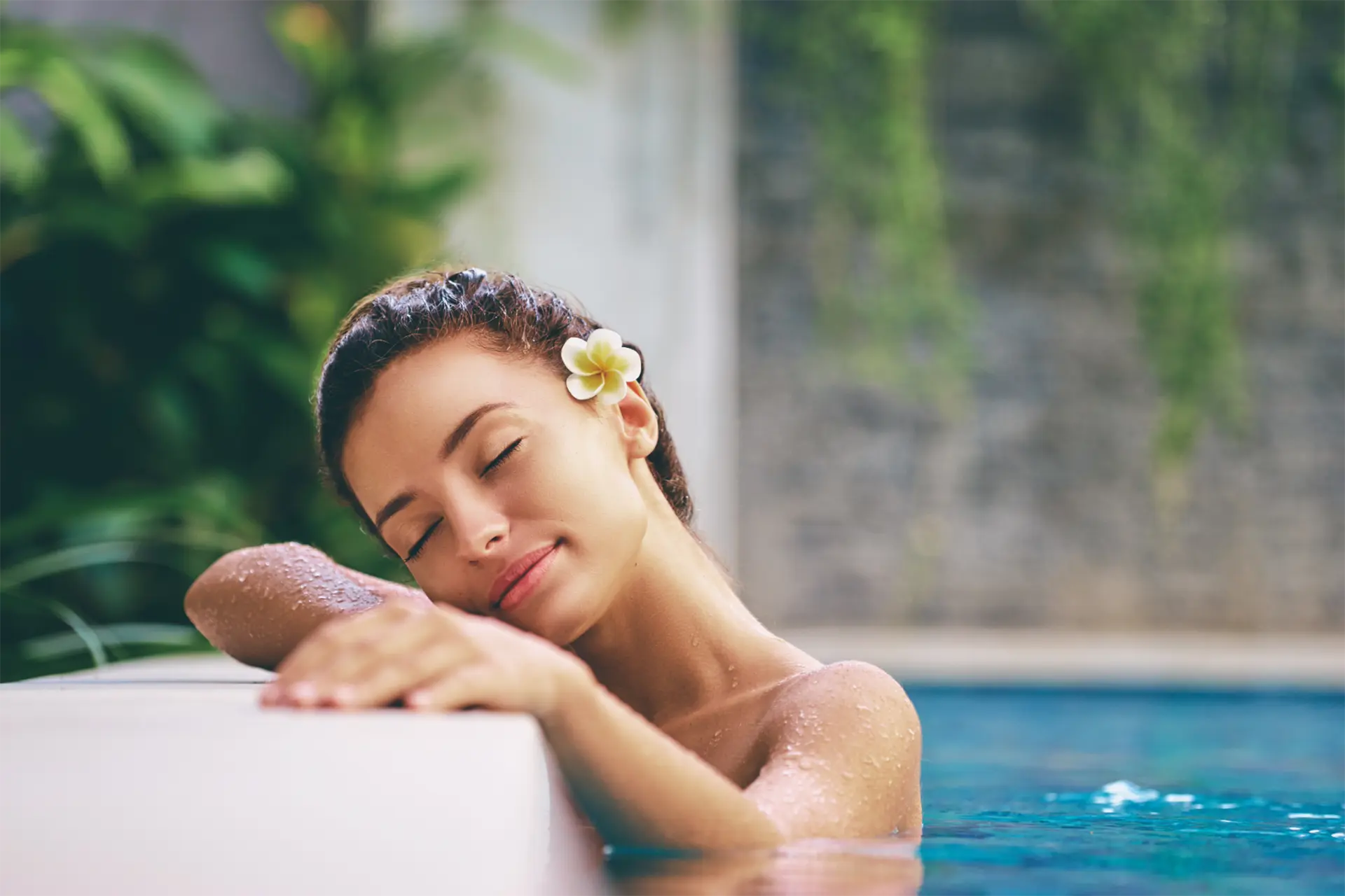 Donna che si rilassa in una piscina spa immersa in un ambiente dedicato al benessere e al relax