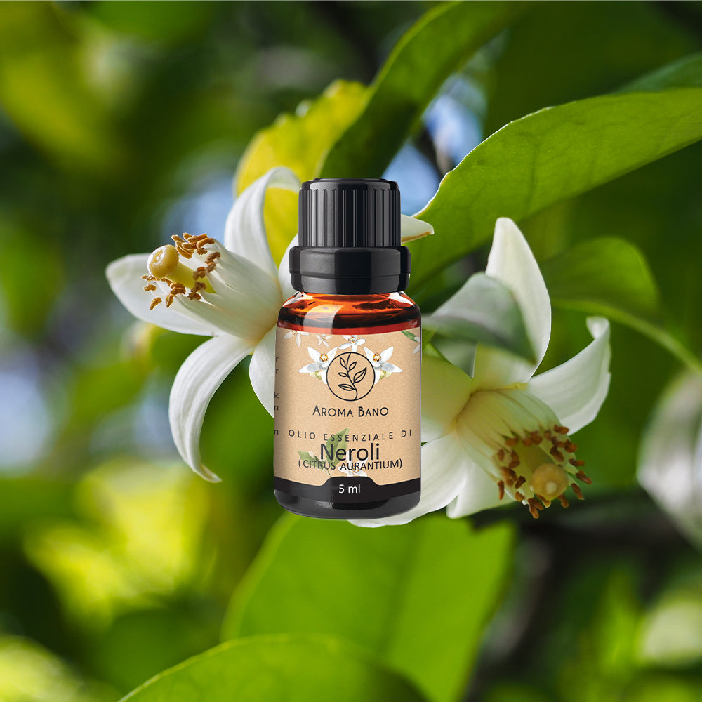 Olio essenziale di Neroli Aroma Bano in bottiglia da 5 ml su sfondo di fiori bianchi di arancio amaro