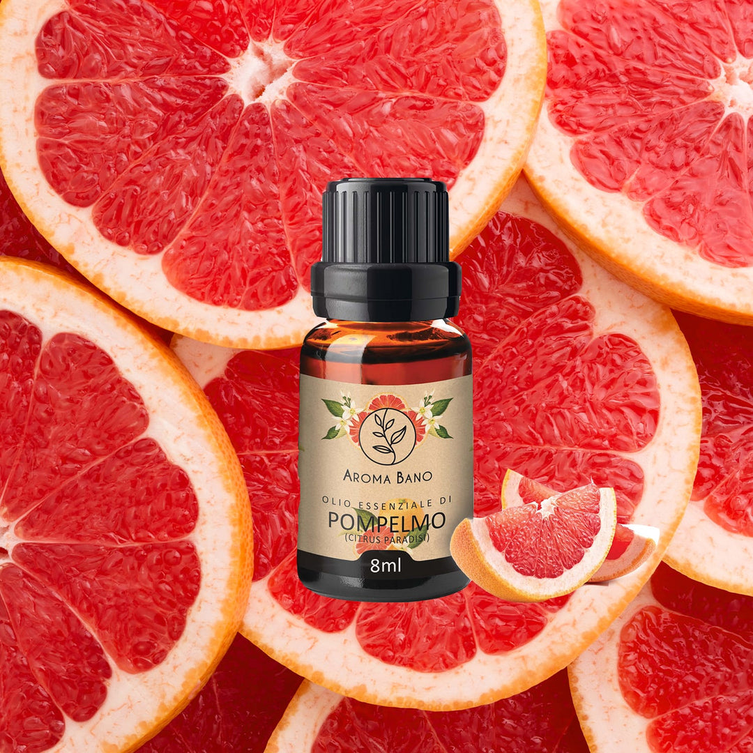 Bottiglia da 8 ml di olio essenziale di Pompelmo Aroma Bano posizionata su fette di pompelmo fresco